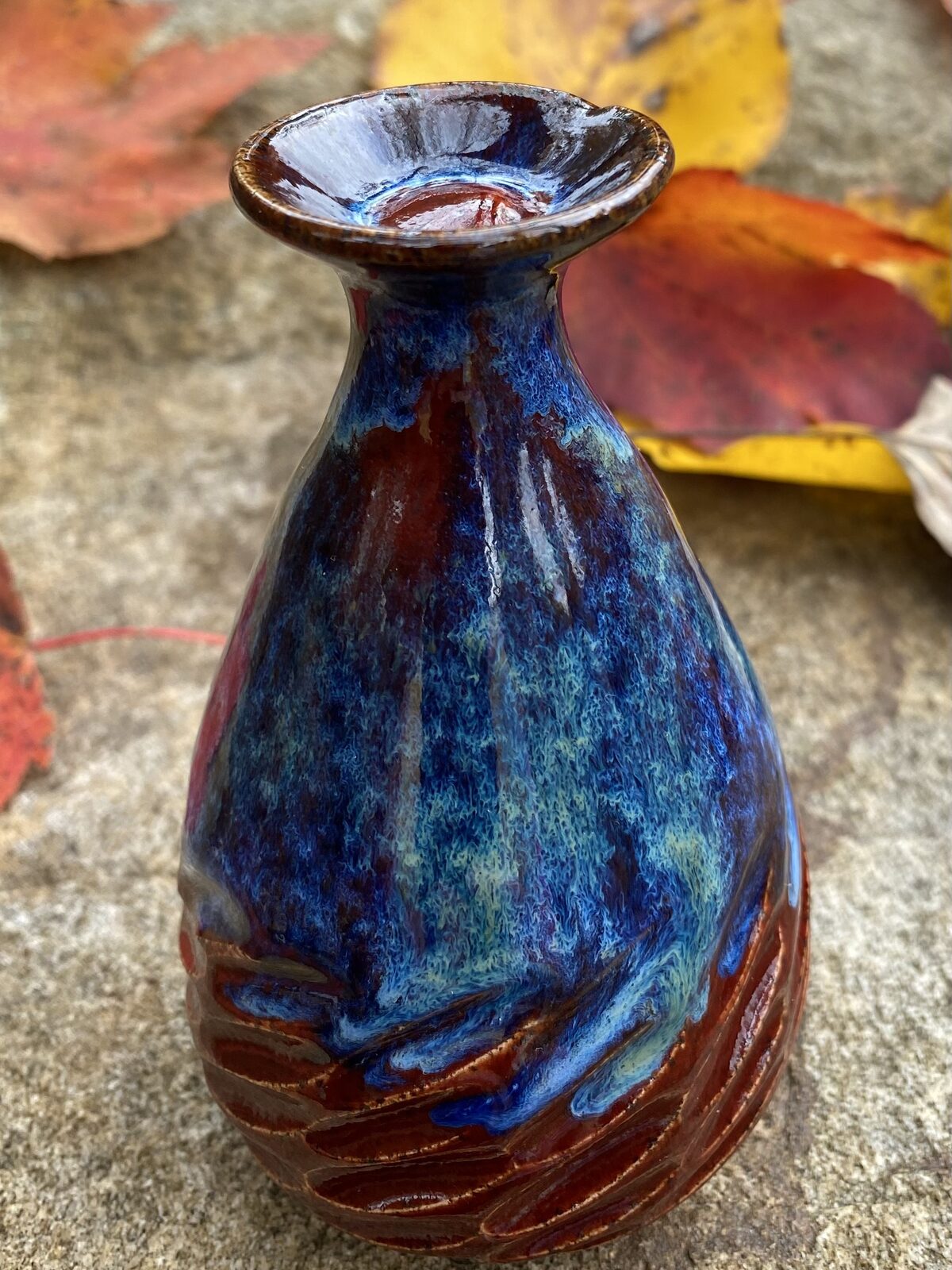 Small bottle vase with flared rim, deep blue and red drip glaze, with carved facets at the base