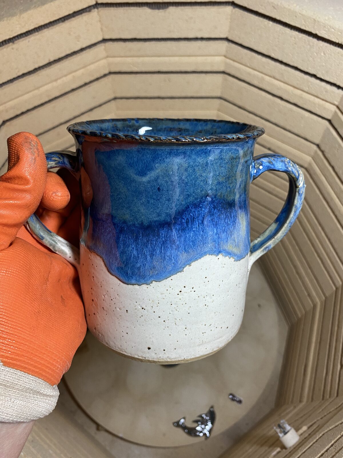 Two-handled vessel with vivid blue glaze cascading over white speckled stoneware, fresh from the kiln